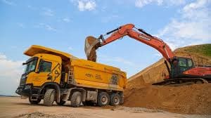 Dump truck and excavator at a working quarry or construction zone