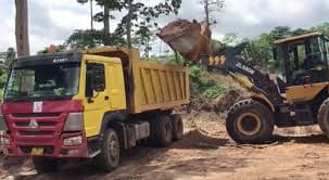 Tipper truck being loaded by a front-end loader on site
